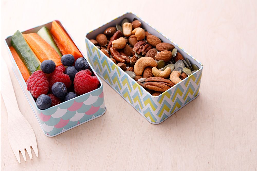 2 boxes of healthy snacks including nuts and fruit.