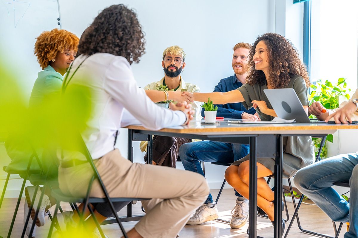 People greeting around a table during a networking event